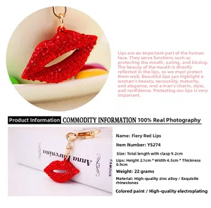 Detail of red rhinestone studded lips keychain with gold metal chain for women