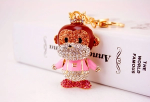 Detail of cartoon monkey keychain featuring colorful rhinestones and a gold crown charm
