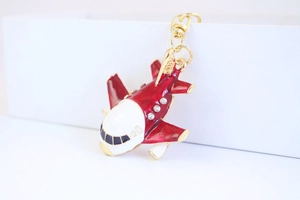 Détail macro du porte-clés avion A380 avec émail rouge blanc et strass étincelants
