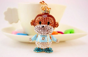Close-up of golden crown monkey keychain with sparkling rhinestones and enamel number 2