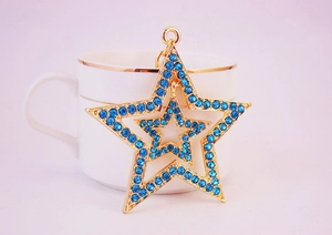 Detail of a double-layered star keychain with blue rhinestones and gold plating