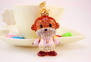 Close-up of a sparkling crystal monkey keychain with pink outfit and golden hook