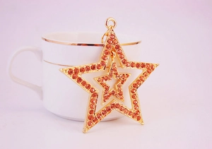 Close-up of double-layer hollow star keychain with amber rhinestones on a gold base