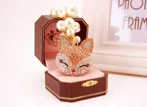 Detail of fox-shaped rhinestone keychain with pearls in an octagonal jewelry box