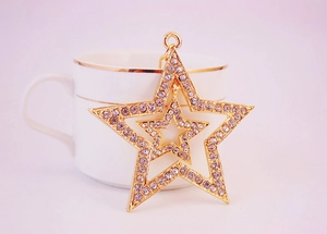 Close-up of double-layer hollow star keychain with sparkling rhinestones and gold finish