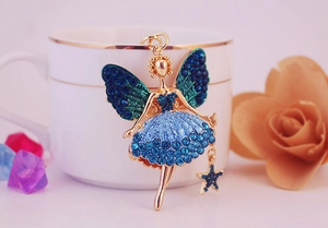 Vue détaillée du porte-clés ange doré avec des strass bleus sur une tasse