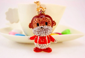 Detail showing the monkey keychain with crystal crown and red enamel suspenders