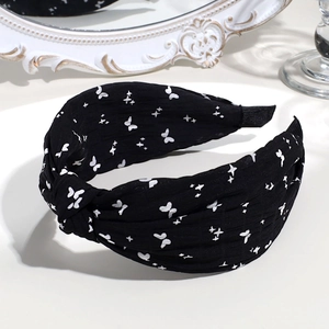 Knotted fabric headband in black with white butterfly and star print detail