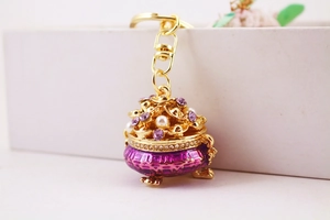 Macro shot of purple enamel treasure pot keychain with diamonds and pearls