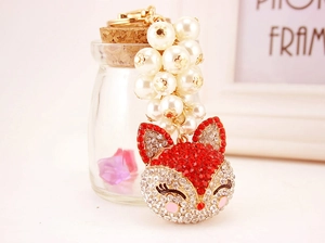 Detail of fox head keychain with red rhinestones and white imitation pearl beads