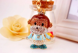 Detailed view of monkey keychain featuring champagne rhinestones and gold plating