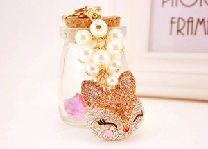 Close-up of elegant fox head keychain with faux pearls and sparkling rhinestones
