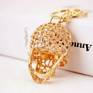 Golden skeleton skull keychain with crystal embellishment and intricate hollow metal design