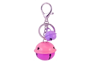 Dettaglio di campanellini in metallo rosa e viola con stelle su moschettone argento