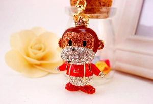 Close-up of golden zodiac monkey keychain with crystal crown and red enamel detail
