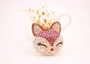 Close-up of sparkling pink rhinestone fox keychain with elegant cream faux pearls