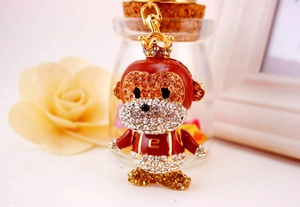 Detail of red enamel monkey keychain with shiny rhinestones and golden crown decoration