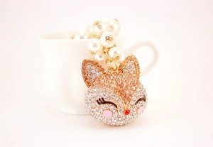 Detailed view of champagne gold fox keychain with white pearls and sparkling rhinestones