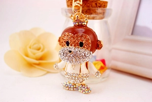 Detailed close-up of a cartoon monkey keychain with sparkling rhinestones and a gold crown