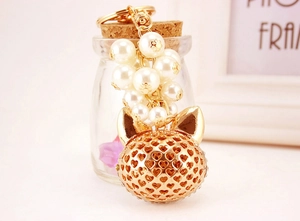 Detail of fox head keychain with hollow heart patterns and white imitation pearls