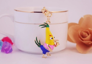 Close-up of a cartoon chicken keychain with yellow enamel, rhinestones and a metal clasp