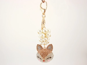 Detailed view of fox head keychain with rhinestones, faux pearls and golden clasp