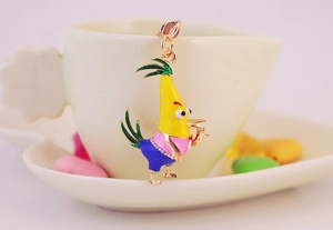 Close-up of yellow cartoon bird keychain with rhinestones hanging on a coffee cup