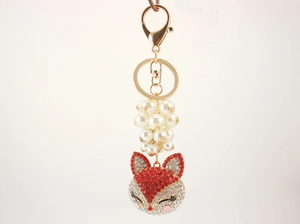 Detail of fox head keychain with red and white rhinestones and faux pearls