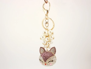 Detailed close-up of a fox-shaped keychain with pink crystals and white pearls decoration