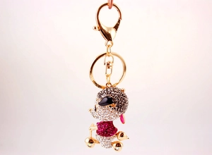 Detailed close-up of a sparkling mouse figurine keychain with shiny gold plating