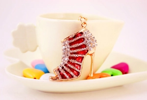 Detail shot of a red rhinestone high heel keychain hanging on a white ceramic mug rim