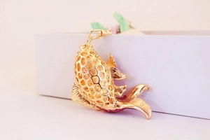 Detailed close-up of golden hollow koi fish keychain with red rhinestones and swivel clasp