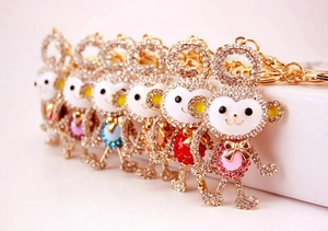 Macro detail of monkey keychains featuring colorful crystal bellies and gold-tone plating