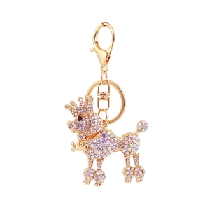 Golden poodle keychain with crown and colorful crystals on a polished metal ring