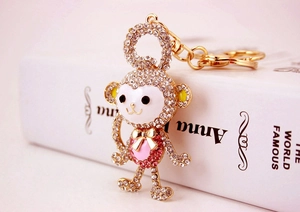 Macro detail of crystal rhinestone monkey keychain with gold finish and enamel face