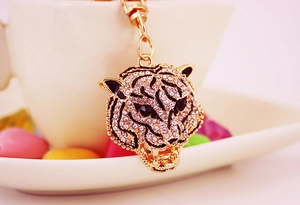 Macro shot of gold leopard head keychain with rhinestones and black enamel details