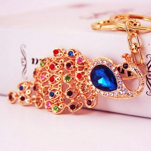 Colorful peacock keychain with vibrant rhinestones and blue crystal on a gold metal base