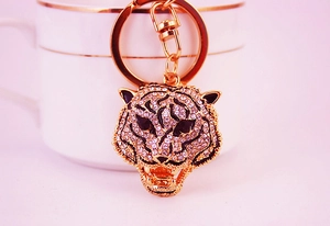 Detail of creative leopard head keychain with rhinestones and black enamel on a cup