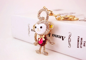 Macro detail showing the crystal encrusted monkey keychain with pink heart and gold finish