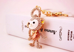 Close-up of golden monkey keychain with white crystals and enamel detailing