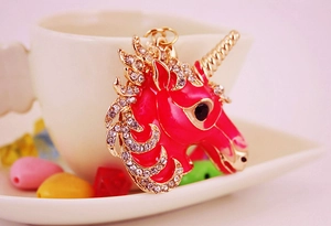 Detail of pink enamel unicorn keychain with sparkling rhinestones and golden metal frame