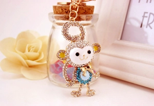 Detail of crystal encrusted monkey keychain with blue rhinestones and gold bow decoration