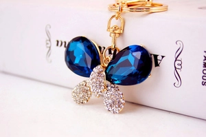 Détail macro du porte-clés papillon avec cristaux bleus et strass blancs brillants