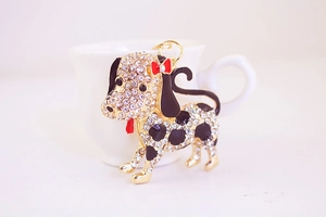 Close-up of Dalmatian crystal keychain with rhinestones leaning against a ceramic cup