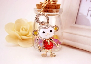 Macro shot of the crystal-studded monkey keychain with detailed golden lobster clasp
