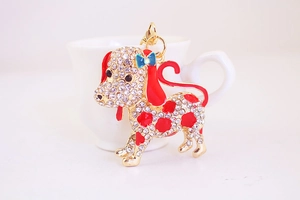 Detail of cute dalmatian puppy keychain with rhinestones leaning on a coffee cup