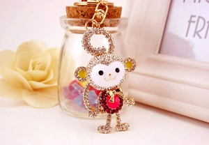 Detail shot of golden monkey keychain with sparkling rhinestones and white enamel finish