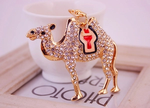Detailed close-up of a golden camel keychain featuring sparkling rhinestones and enamel craft