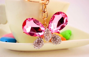 Vue rapprochée du porte-clés papillon en cristal rose avec strass et fermoir mousqueton doré