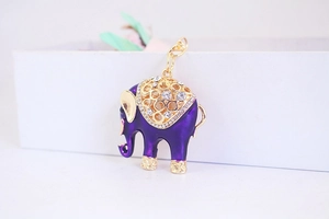 Vista macro del ciondolo elefante in smalto viola con strass lucidi e dettagli dorati